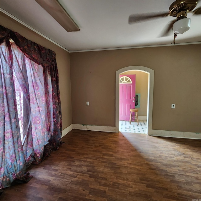 unfurnished room featuring ceiling fan, dark hardwood / wood-style flooring, and crown molding