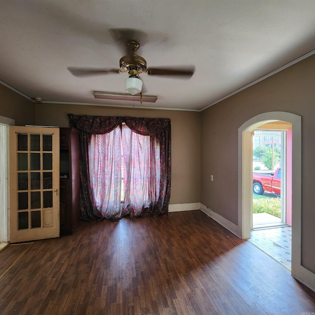 unfurnished room featuring ornamental molding, ceiling fan, and dark wood-type flooring