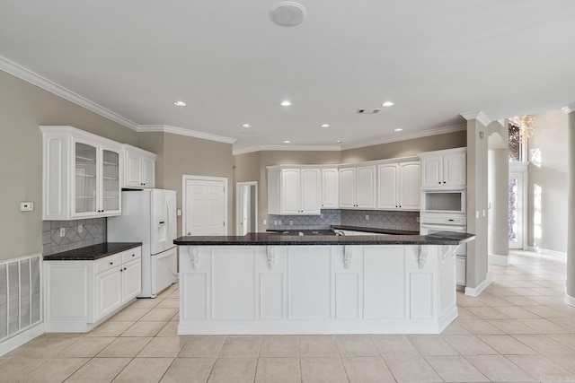 kitchen with decorative backsplash, light tile patterned floors, white appliances, and white cabinetry