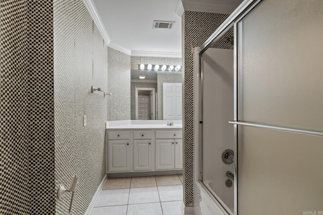 bathroom featuring tile patterned flooring, vanity, crown molding, and enclosed tub / shower combo