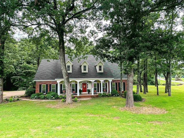 cape cod house with covered porch and a front lawn