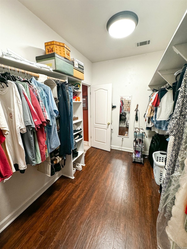 walk in closet with dark hardwood / wood-style flooring