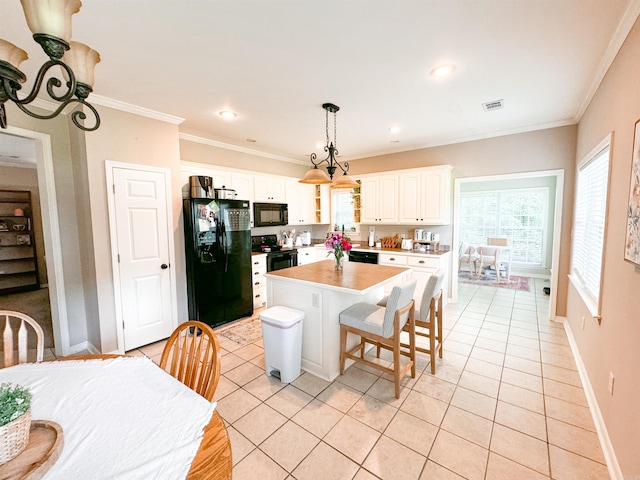 kitchen with black appliances, light tile patterned floors, decorative light fixtures, a center island, and white cabinetry