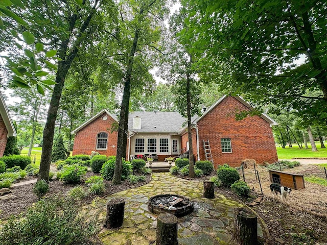 rear view of property featuring a deck, an outdoor fire pit, and a patio