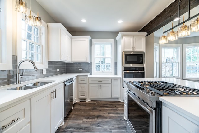 kitchen with pendant lighting, sink, white cabinets, and stainless steel appliances