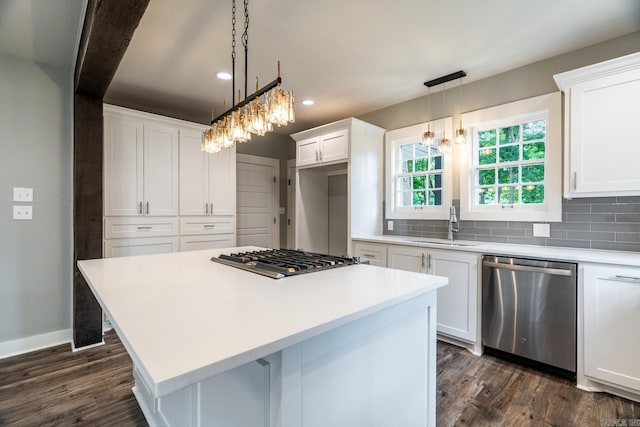 kitchen featuring backsplash, white cabinets, decorative light fixtures, and appliances with stainless steel finishes