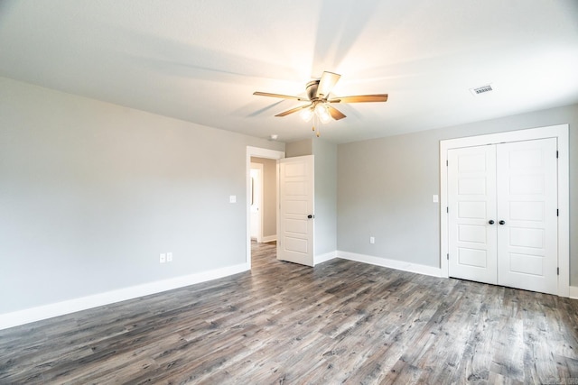 unfurnished bedroom featuring a closet, ceiling fan, and dark wood-type flooring