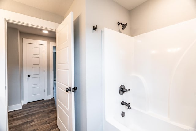 bathroom with shower / bathing tub combination and hardwood / wood-style floors