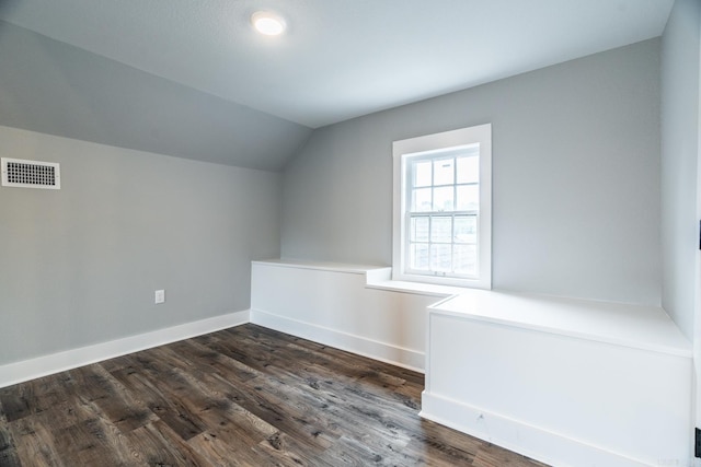 additional living space featuring dark hardwood / wood-style floors and vaulted ceiling