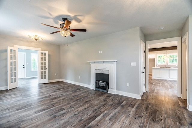 unfurnished living room featuring french doors, dark hardwood / wood-style flooring, ceiling fan, and a premium fireplace