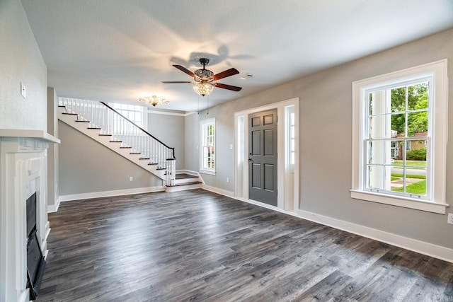 unfurnished living room with ceiling fan and dark wood-type flooring