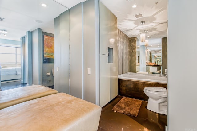 bathroom featuring toilet, a tub, and concrete floors