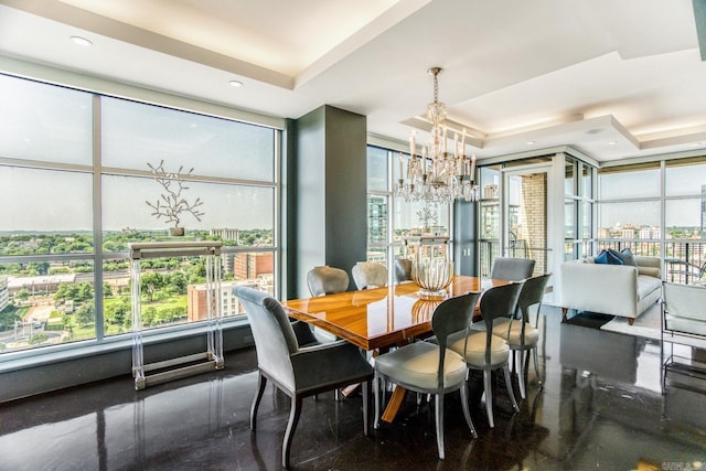 dining space with a chandelier, a tray ceiling, and a wealth of natural light