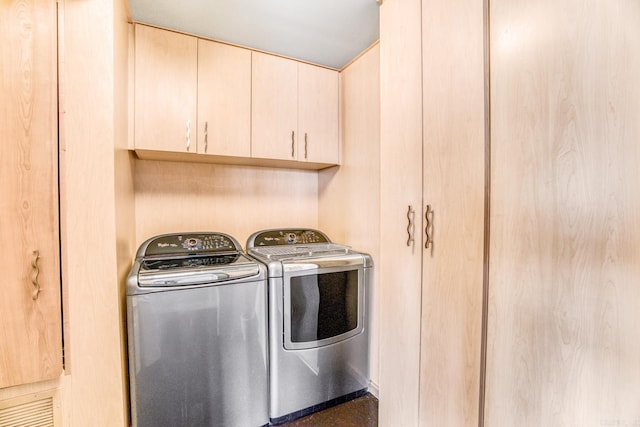 laundry area with washer and clothes dryer and cabinets