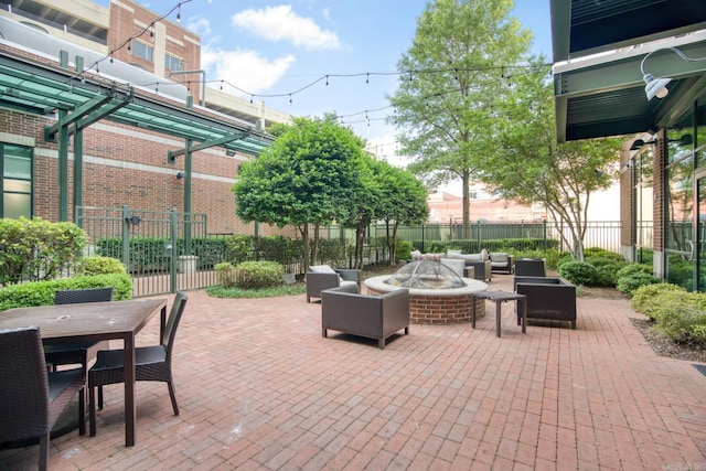 view of patio with an outdoor living space with a fire pit