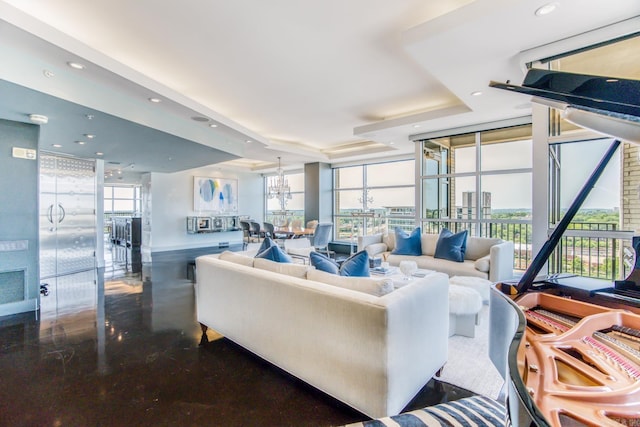 living room featuring a tray ceiling and a wall of windows