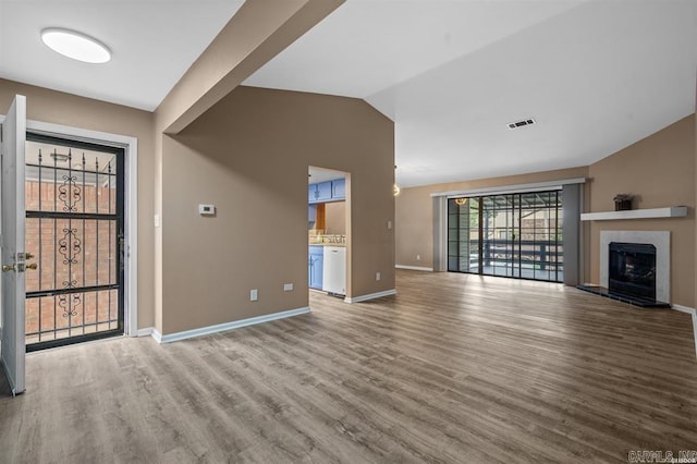 unfurnished living room with hardwood / wood-style flooring and lofted ceiling