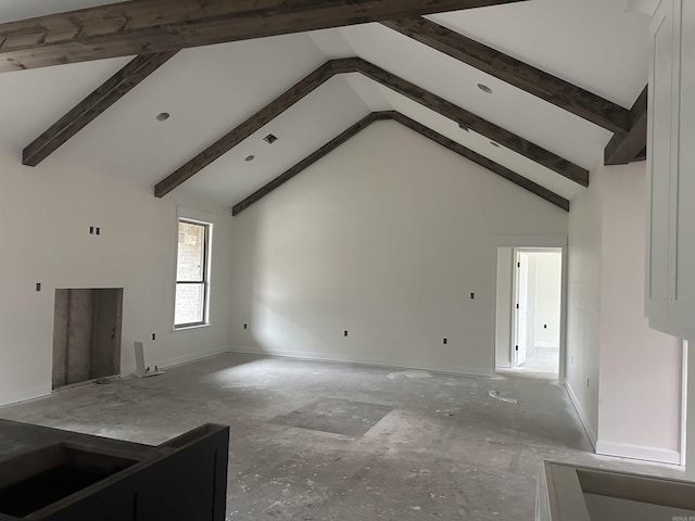 unfurnished living room featuring beam ceiling and high vaulted ceiling