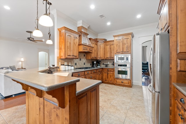 kitchen with backsplash, ceiling fan, ornamental molding, appliances with stainless steel finishes, and kitchen peninsula