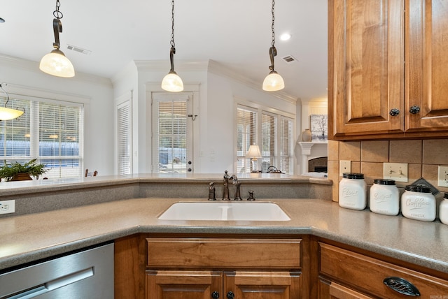 kitchen featuring dishwasher, decorative light fixtures, crown molding, and sink