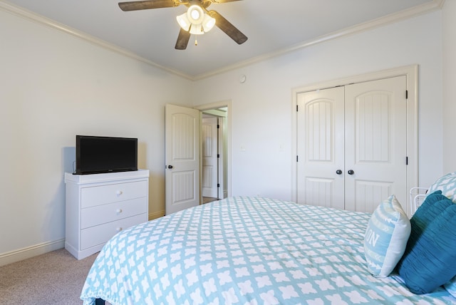 carpeted bedroom featuring a closet, ceiling fan, and crown molding