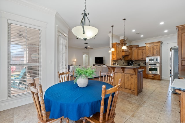 dining area featuring ceiling fan, ornamental molding, and light tile patterned floors