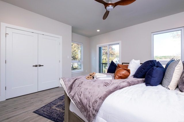 bedroom with a closet, ceiling fan, and light hardwood / wood-style flooring