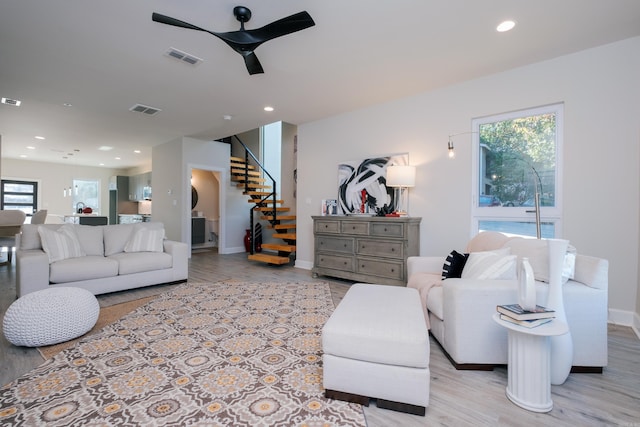 living room with ceiling fan and light wood-type flooring