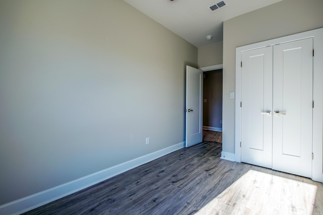 unfurnished bedroom with a closet and wood-type flooring