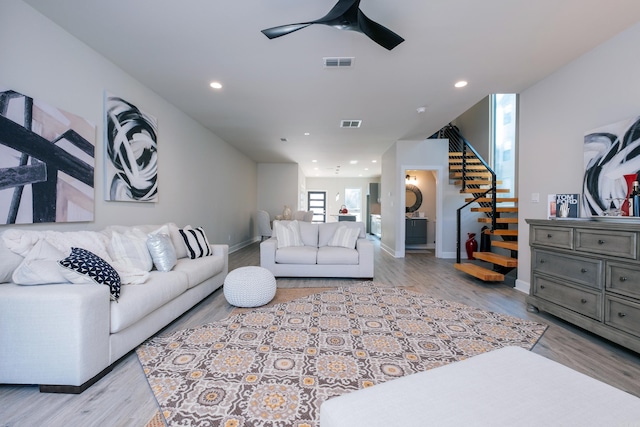 living room with light wood-type flooring and ceiling fan