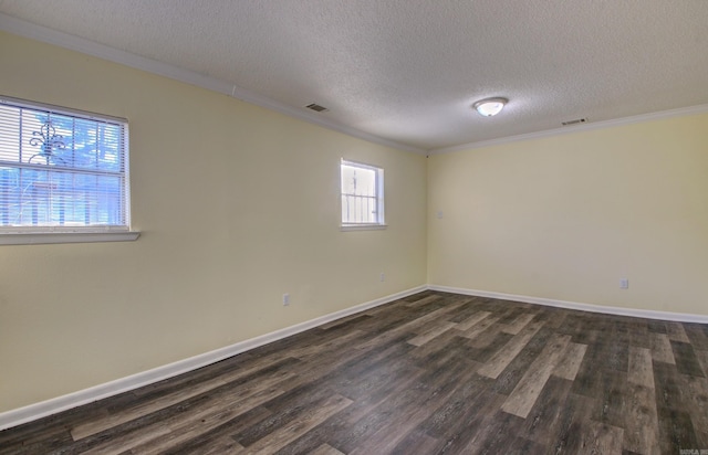 spare room with a textured ceiling, ornamental molding, and dark wood-type flooring