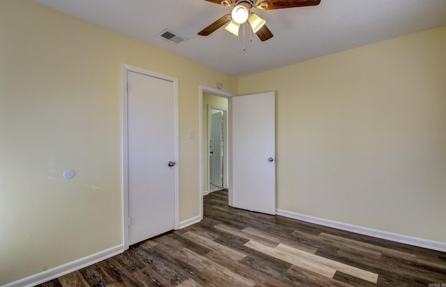 empty room with ceiling fan and dark wood-type flooring