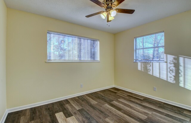 spare room with ceiling fan and dark hardwood / wood-style floors