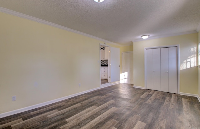 unfurnished bedroom featuring a textured ceiling, dark hardwood / wood-style flooring, a closet, and ornamental molding