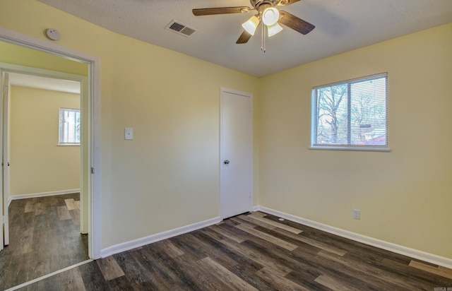 unfurnished bedroom featuring a closet, ceiling fan, dark hardwood / wood-style flooring, and a textured ceiling