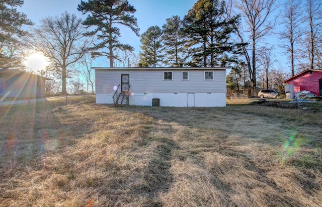 rear view of property with a lawn and cooling unit