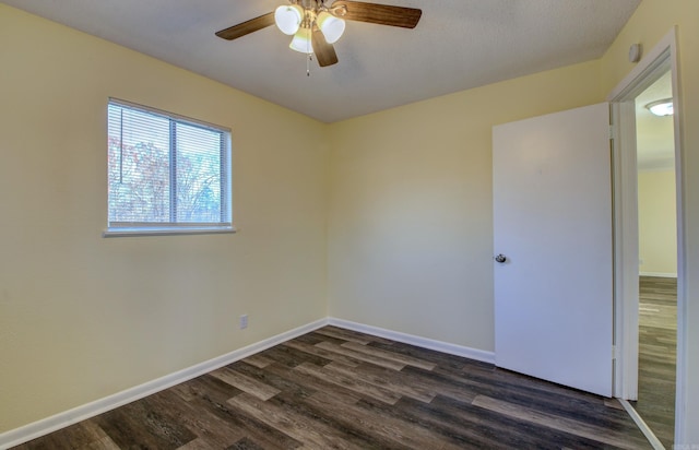 unfurnished room featuring ceiling fan and dark wood-type flooring