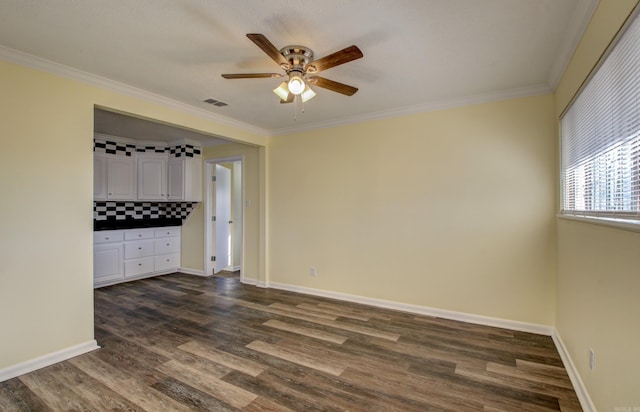 unfurnished room featuring ceiling fan, dark hardwood / wood-style flooring, and ornamental molding