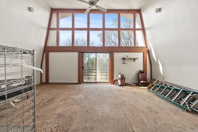 living room featuring ceiling fan and a high ceiling