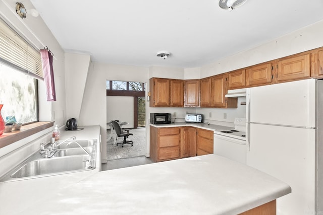 kitchen featuring sink, white appliances, and kitchen peninsula