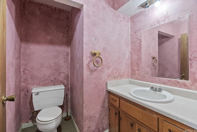 bathroom featuring vanity, toilet, and a textured ceiling