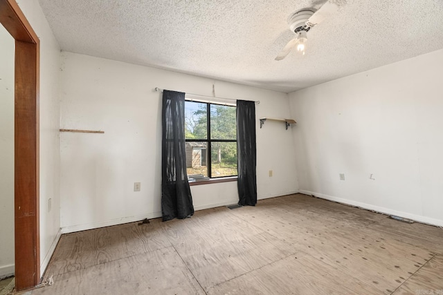 unfurnished room with ceiling fan and a textured ceiling