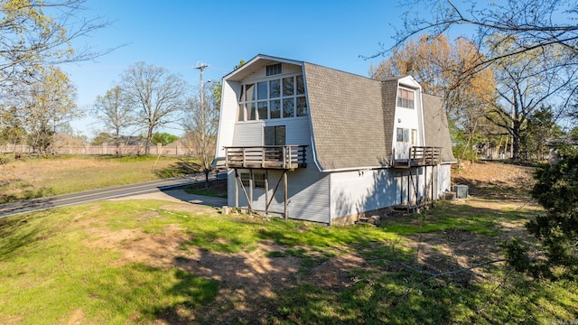 back of house featuring central air condition unit and a yard