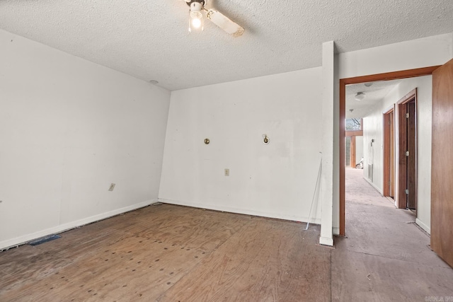 unfurnished room with ceiling fan and a textured ceiling