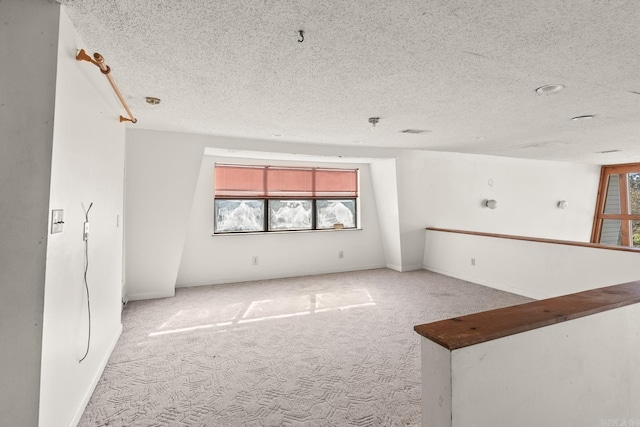 unfurnished room with light colored carpet and a textured ceiling