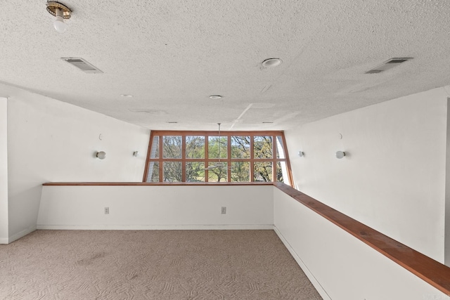 empty room with carpet flooring and a textured ceiling