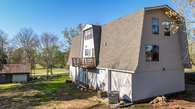 rear view of house with cooling unit and a storage unit