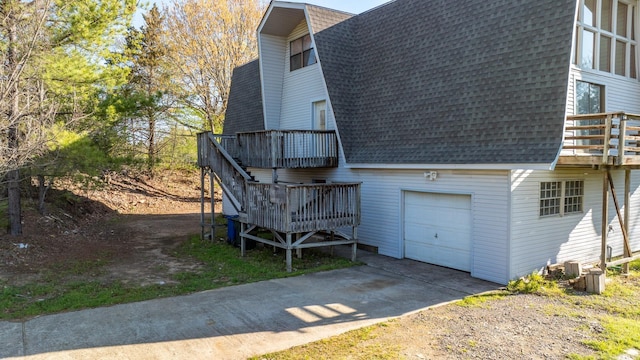 view of property exterior with a garage and a wooden deck