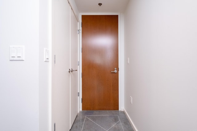 doorway featuring dark tile patterned flooring