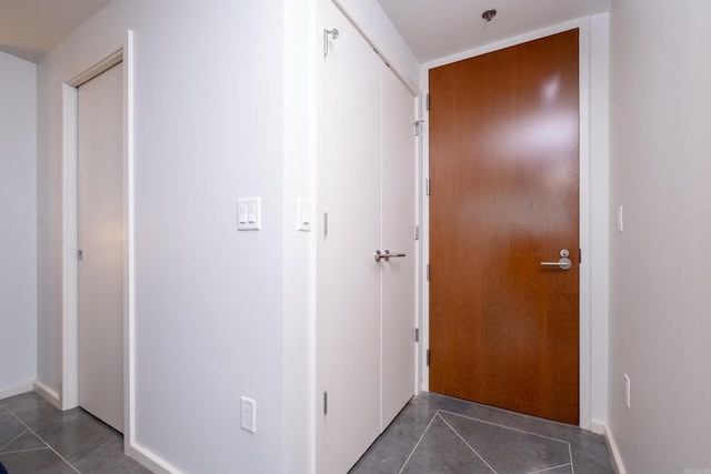 corridor with dark tile patterned flooring